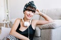 Close-up photo of blissful young lady wearing black silk tank-top relaxing in home at weekend. Indoor portrait of