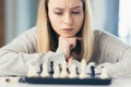 Close-up photo of a blonde woman playing chess, thoughtfully making a move Royalty Free Stock Photo