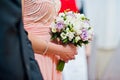 Close-up photo of bridesmaid`s hands holding wedding bouquet in Royalty Free Stock Photo