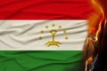 Close-up photo of burning national flag of state of Tajikistan, concept of state crisis, destruction, illustration