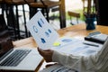 Close-up photo. Businessman holding pen and pointing at financial documents with financial marketing network diagram and working o