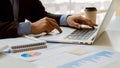 Close-up photo. Businessman holding pen and pointing at financial documents with financial marketing network diagram and working o