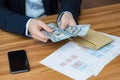 Close-up photo of businessman`s hands counting US dollars, man in business suit