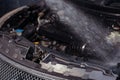 A close-up photo of a car engine being washed with water