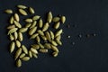 Close up photo of Cardamom pods and seeds pile on the matt black background. It is very popular in Indian and Sri Lanka cuisine