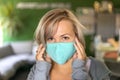 Close up photo of a caucasian woman with blonde hair wearing a medical mask at the office. Portrait at work.