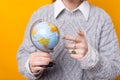 Close up photo of causal woman pointing on globe over yellow background Royalty Free Stock Photo