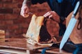 Close-up photo of a chef cook cutting exclusive jerky meat on table in a kitchen with loft interior. Royalty Free Stock Photo