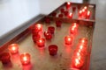 Close-up photo of church candles in red transparent chandeliers Royalty Free Stock Photo