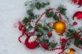 Close up photo of a coniferous branches decorated with toys for the Christmas tree lie in the snow on the right side of the frame Royalty Free Stock Photo