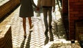 Close up photo of couple`s legs  walking on street at sunset. Royalty Free Stock Photo