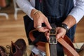 close-up photo of crafstman comparing leather belts during work Royalty Free Stock Photo