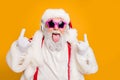 Close up photo of crazy funny hipster santa claus show horns sign tongue-out want rock-and-roll concert instead x-mas