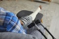 Close-up photo of a crutch on the background of a man& x27;s leg in a cast on the sofa.