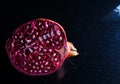 Close up photo of cut pomegranate in dark background