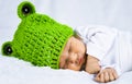 Close up head photo of a cute happy looking adorable newborn baby with green cap Royalty Free Stock Photo