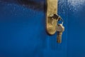 Close up photo of door lock with keys in it on the blue door Royalty Free Stock Photo