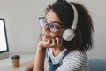 Close-up photo of dreamy girl with light-brown skin thinking about something pleasant while enjoying music. Indoor Royalty Free Stock Photo