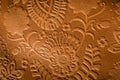 Close up photo of embossed leather with a floral design in rust brown. Royalty Free Stock Photo