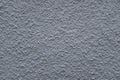 A close up photo of an exterior textured wall painted gray, surface with stucco daub, great for background