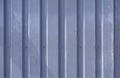 Close up photo of a facade from an industrial building with graphic stripes of minimalistic vertical blue weathered metal profiles