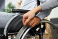 Close up of female touching hand of disabled man in wheelchair for support