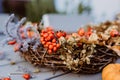 Close up photo of floral autumn door wreath made from natural materials: colorful rosehip berries, rowan, dry flowers and plants Royalty Free Stock Photo