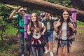 Close up photo of four friends enjoying the beauty of nature, hiking in wild forest, looking for a nice place for camp, smiling, e