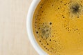 Close up photo of fresh espresso with foam in white cup, top view from above Royalty Free Stock Photo