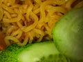 close-up photo of fried noodles and cucumber