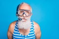 Close up photo of funky retired man having snorkel gear look wearing striped swim wear  over blue background Royalty Free Stock Photo