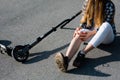 Close up photo of girl checks a bruised knee that suffered from a fall while riding a scooter on the street