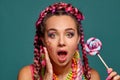 Lovely girl with a multi-colored braids hairstyle and bright make-up, posing in studio against a blue background Royalty Free Stock Photo