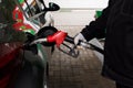 Close-up photo of hand holding fuel pump and refilling car at petrol station Royalty Free Stock Photo