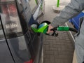 Close-up photo of hand holding fuel pump and refilling car at petrol station Royalty Free Stock Photo