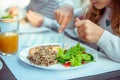 Close up photo of hands of child girl eating healthy dinner with salad, quinoa and fish Royalty Free Stock Photo