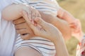 Close up photo of hands of family with toddler holding him and taking care of him