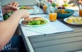 Close up photo of hands man eating salad, quinoa and fish on terrace