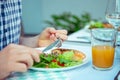 Close up photo of hands man eating salad, quinoa and fish on terrace Royalty Free Stock Photo