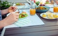 Close up photo of hands man eating salad, quinoa and fish on terrace