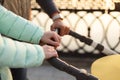 Close up of young loving family hands holding baby pram by the lake. Parents with stroller in autumn park on sunset. Love, parenth Royalty Free Stock Photo