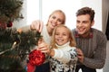 Happy family decorating christmas tree at home Royalty Free Stock Photo