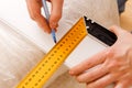 Close up photo of hardworking holding ruler and pencil while making marks on wood at table Royalty Free Stock Photo