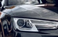 Close-up photo of headlight on dark grey car. Royalty Free Stock Photo