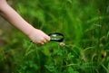 Close-up photo of kid exploring nature with magnifying glass