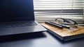 close-up photo of laptop, batik book, pen and glasses