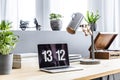 Close-up photo of laptop with clock screensaver placed on wooden