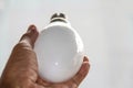 close up photo of a light bulb in a man& x27;s hand, isolated on a white background. Royalty Free Stock Photo