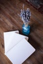 Close-up photo of light pink scheduler notebook on a wooden table with lavender.