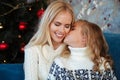 Close-up photo of little girl in knitted sweater kiss her mother Royalty Free Stock Photo